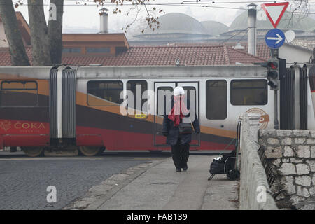 Sarajevo, Bosnie-Herzégovine. Dec 25, 2015. Une femme marche dans la rue dans la brume sèche à Sarajevo, Bosnie-Herzégovine, le 25 décembre, 2015. En raison de la pollution atmosphérique, toutes les écoles primaires et secondaires du canton de Sarajevo sont fermées le 24 décembre et le 25 décembre. Credit : Haris Memija/Xinhua/Alamy Live News Banque D'Images