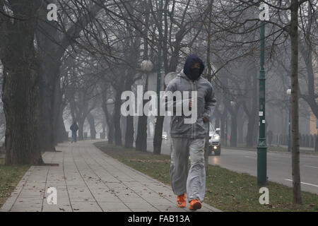 Sarajevo, Bosnie-Herzégovine. Dec 25, 2015. Un homme marche dans la rue portant des masques à Sarajevo, Bosnie-Herzégovine, le 25 décembre, 2015. En raison de la pollution atmosphérique, toutes les écoles primaires et secondaires du canton de Sarajevo sont fermées le 24 décembre et le 25 décembre. Credit : Haris Memija/Xinhua/Alamy Live News Banque D'Images