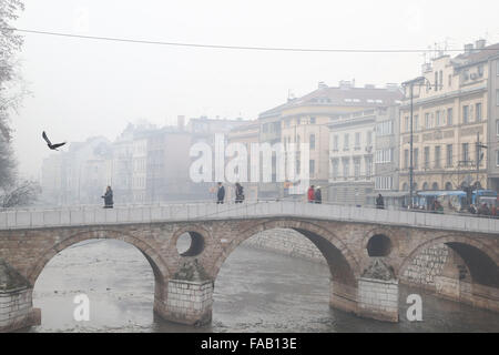 Sarajevo, Bosnie-Herzégovine. Dec 25, 2015. Les gens marchent dans la brume sèche à Sarajevo, Bosnie-Herzégovine, le 25 décembre, 2015. En raison de la pollution atmosphérique, toutes les écoles primaires et secondaires du canton de Sarajevo sont fermées le 24 décembre et le 25 décembre. Credit : Haris Memija/Xinhua/Alamy Live News Banque D'Images