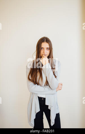 Lonely Girl sitting behind Christmas Tree with presents Banque D'Images