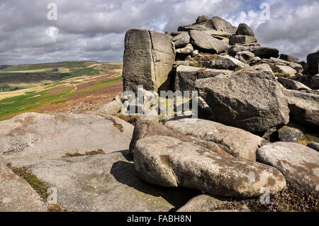 Les roches pierre meulière sur plus Owler Tor dans le Peak District, Derbyshire. Paysage avec des promeneurs. populaires Banque D'Images