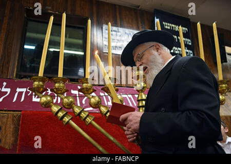 Un rabbin juif orthodoxe en récitant les bénédictions avant d'allumer les bougies d'un Chanukkah Menorah géante. À Brooklyn, New York Banque D'Images