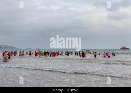 Torquay, Royaume-Uni, le 26 décembre 2015. 'À pied dans la mer' Boxing Day charity event organisé par le Lions Club de Paignton. Fêtards locaux ont bravé des conditions venteuses de participer au lendemain de tradition d'une baignade dans les eaux de la baie de Tor de la plage de Paignton ; avec beaucoup de porter des vêtements de fête ou fantaisie robe pour récolter des fonds pour la charité. Credit : Clive Jones/Alamy Live News Banque D'Images