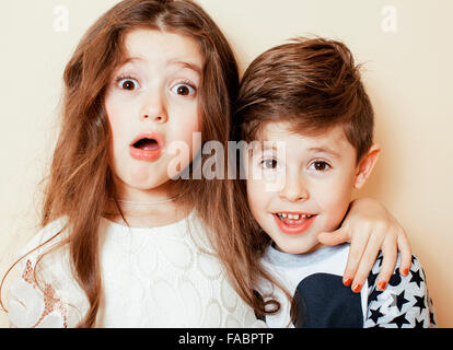 Peu cute boy and girl hugging jouant sur fond blanc, happy family smiling Banque D'Images