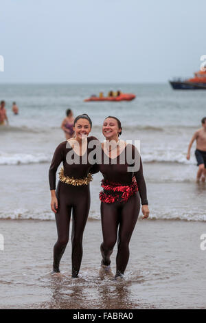 Torquay, Royaume-Uni, le 26 décembre 2015. 'À pied dans la mer' Boxing Day charity event organisé par le Lions Club de Paignton. Fêtards locaux ont bravé des conditions venteuses de participer au lendemain de tradition d'une baignade dans les eaux de la baie de Tor de la plage de Paignton ; avec beaucoup de porter des vêtements de fête ou fantaisie robe pour récolter des fonds pour la charité. Credit : Clive Jones/Alamy Live News Banque D'Images