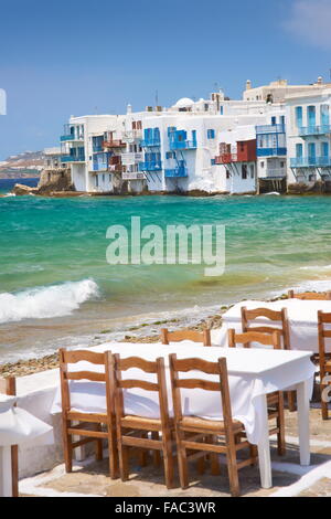 Café restaurant dans la ville de Mykonos, Chora, la Petite Venise dans l'arrière-plan - l'île de Mykonos, Cyclades, Grèce Banque D'Images