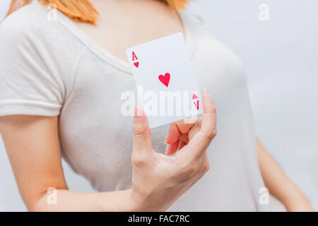 Jeune femme tenant en main poker carte avec combinaison de la pleine Chambre. à la main et carte de poker. Banque D'Images