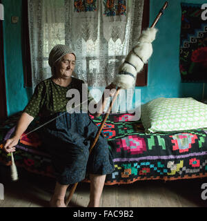 Femme âgée alors que la filature de la laine dans le district de Maramures, Roumanie Banque D'Images