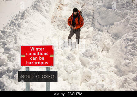 Un marcheur parmi les amoncellements de neige massives de bloquer l'Kirkstone Pass Road au-dessus de Ambleside dans le Lake District, UK au cours de l'événement météorologique extrême de la fin de mars 2013. cliché pris le 25 mars 2013. Banque D'Images