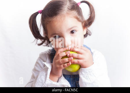 Portrait of happy girl mordre une pomme verte. Plus isolé sur fond blanc Banque D'Images