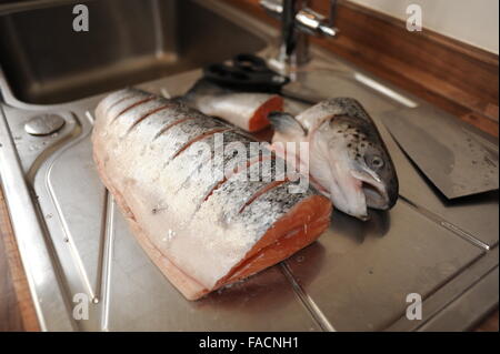 Saumon entier en préparation pour la cuisson à l'évier de cuisine Banque D'Images