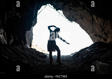 Le tourisme représente en silhouette et fait des formes dans une grotte, le long du rivage du Parc National de Cinque Terre Italie. Banque D'Images