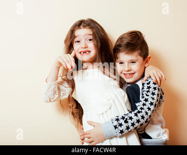 Peu cute boy girl hugging jouant sur fond blanc, happy family portrait isolé. brother and sister smiling Banque D'Images