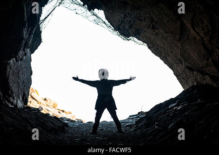 Le tourisme représente en silhouette et fait des formes dans une grotte, le long du rivage du Parc National de Cinque Terre Italie. Banque D'Images