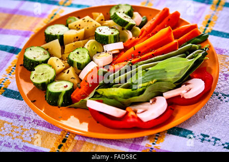 Louche de jeunes légumes fraîchement récoltés à la vapeur y compris les carottes, en Coupe ondulée, de pois et de pommes de terre des matraques Banque D'Images