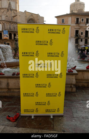 Une paire de chaussures rouges a été placé en face d'une bannière d'Amnesty International. Amnesty International placé chaussures rouges à la Placa de la Verge à Valence comme un signe contre la violence contre les femmes. Chaque paire de chaussures représentant une victime de la violence de genre. Cette initiative remonte à l'artiste mexicain Elina Chauvet en 2009. © Michael Debets/Pacific Press/Alamy Live News Banque D'Images