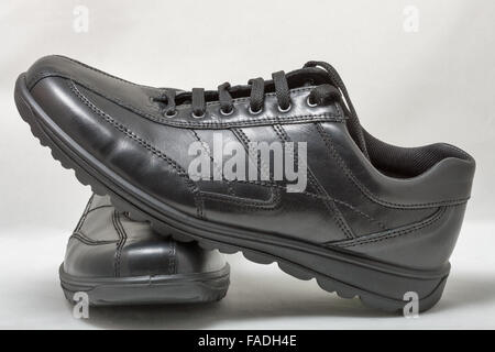 Paire de chaussures en cuir noir avec lacets sur fond blanc Banque D'Images