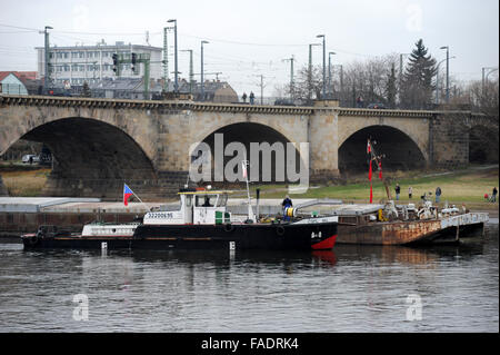 Drazdany, Allemagne. 28 Dec, 2015. République tchèque (remorqueur arrière) est coincé sous le pont Marienbruecke sur l'Elbe à Dresde, Allemagne, le 28 décembre 2015. La LABE (Elbe) l'Autorité du bassin du fleuve a envoyé une vague le long de la rivière pour aider à sauver un navire de charge. Le navire de 90 mètres avec un fret de 1100 tonnes s'est coincé en Allemagne au cours de son voyage à Decin, La Bohême du nord, le dimanche 27. Voir Photo/tug boat qui est arrivé pour aider la République tchèque à bateau. © Zavoral Libor/CTK Photo/Alamy Live News Banque D'Images