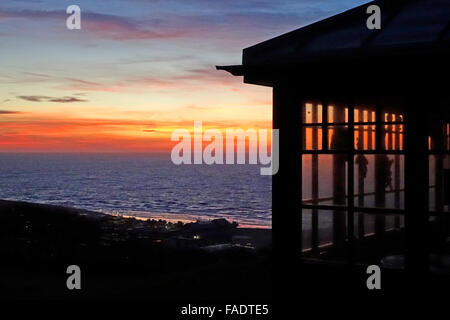 Hastings, Sussex. Le 28 décembre 2015. Lever du soleil sur la mer aux couleurs vives, de West Hill cafe, annonce une belle journée ensoleillée sur la côte sud. Banque D'Images