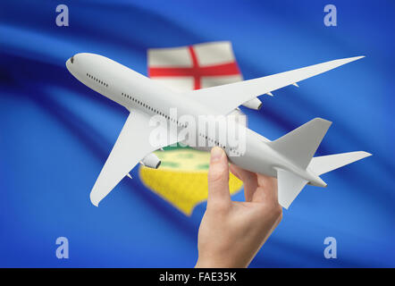 Avion en main avec province ou territoire canadien drapeau sur arrière-plan - Alberta Banque D'Images