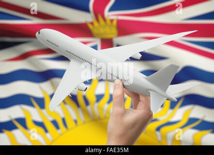 Avion en main avec province ou territoire canadien drapeau sur arrière-plan - Colombie-Britannique Banque D'Images