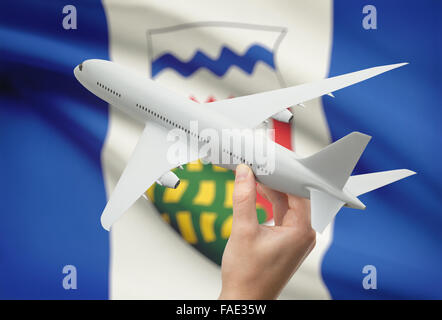 Avion en main avec province ou territoire canadien drapeau sur arrière-plan - Territoires du Nord-Ouest Banque D'Images