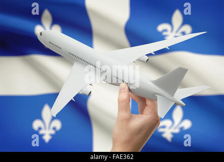 Avion en main avec province ou territoire canadien drapeau sur arrière-plan - Québec Banque D'Images