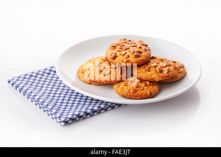 Pile de biscuits faits maison sur une plaque en céramique blanc sur bleu serviette de table, isolé sur fond blanc Banque D'Images