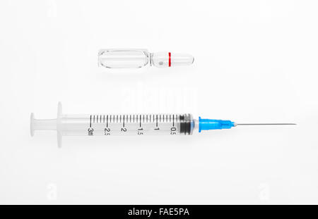 Seringue en plastique avec aiguille ouvert et transparent ampoule en verre blanc avec un médicament isolé sur fond blanc Banque D'Images