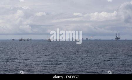 De nombreuses plates-formes pétrolières à l'horizon au large de la côte de Brunéi Darussalam, Mer de Chine du Sud. Ciel nuageux. Banque D'Images