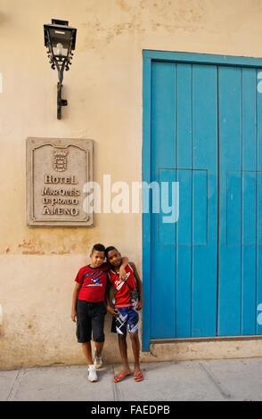 Les garçons se tient en dehors de Hotel Marques de Prado Ameno, Habana Vieja (la vieille Havane), Cuba Banque D'Images