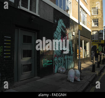 L'ombre ensoleillée vue oblique Bacon Street à Brick Lane avec Dscreet et owl dinosaure cartoon Art, London, E1, UK Banque D'Images