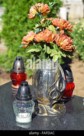 Les lanternes et les fleurs sur la pierre tombale dans le cimetière public Banque D'Images