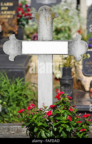 Croix de Pierre et des fleurs dans le cimetière public Banque D'Images