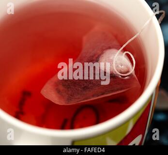 Une infusion à base de fruits rouges boisson chaude avec une pyramide sachet de thé dans un mug close up Banque D'Images