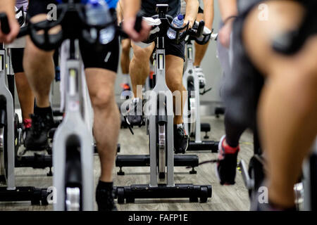 Les bicyclettes stationnaires pendant un cours de gym spinning Banque D'Images