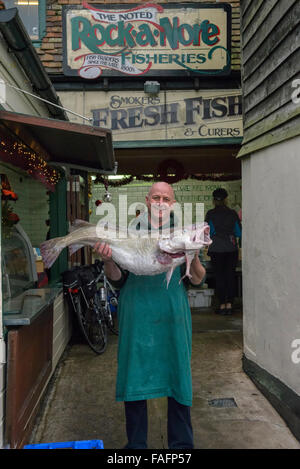 Sonny Elliot, propriétaire de rock-a-pêches Nore, tenant une pêche locale fraîche 40lb cod. Hastings. East Sussex. L'Angleterre. UK. Banque D'Images