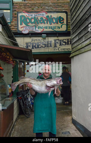 Sonny Elliot, propriétaire de rock-a-pêches Nore, tenant une pêche locale fraîche 40lb cod. Hastings. East Sussex. L'Angleterre. UK. Banque D'Images