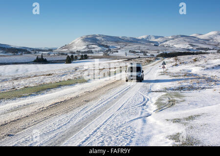 Voiture sur A683 près de Kirkby Stephen qui est recouverte de neige, avec en arrière-plan Cap Sud Fells, Cumbria, Royaume-Uni. Banque D'Images