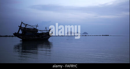 Bateau de pêche échoué sur la plage avec des îles en distance,Koh Phangan, Thaïlande. Banque D'Images