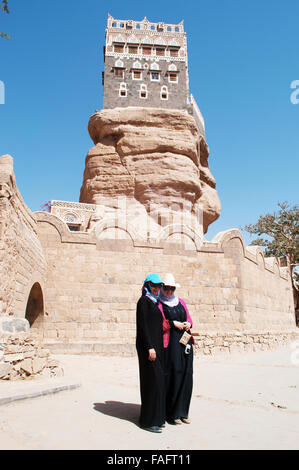 Deux jeunes filles yéménites en face de la Dar al-Hajar, Dar al Hajar, le Rock Palace, palais royal, symbole iconique du Yémen Banque D'Images