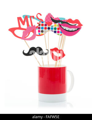 Photo Booth Props dans une tasse rouge sur fond blanc Banque D'Images