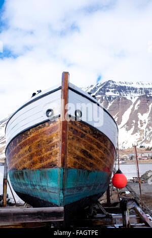 Un seul bateau de pêche sortis de l'eau pour l'entretien en ville Isafjordur soutenu par les falaises des fjords, région de l'Islande westfjords Banque D'Images