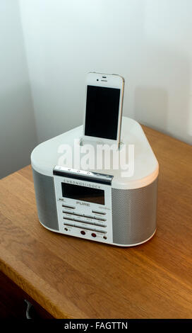 L'iPhone 4S en charge d'un radio-réveil dock Banque D'Images