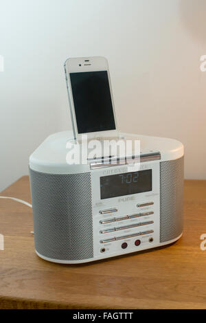 L'iPhone 4S en charge d'un radio-réveil dock Banque D'Images