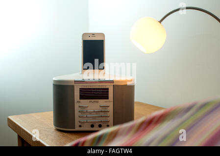 L'iPhone 4S en charge d'un radio-réveil dock Banque D'Images