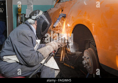 Carrossier restaure un classic car VW Karmann Ghia. Travaux de soudure à la carrosserie du véhicule. Banque D'Images