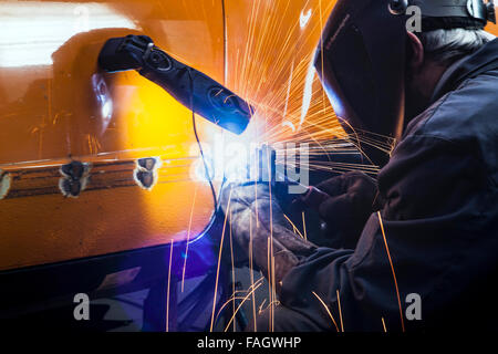 Carrossier restaure un classic car VW Karmann Ghia. Travaux de soudure à la carrosserie du véhicule. Banque D'Images