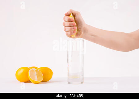 Serrant la main de femme pièce orange pour obtenir le jus. Banque D'Images