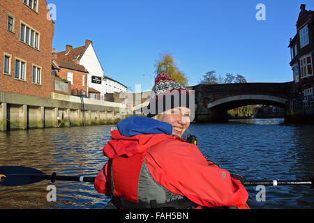 Jeune femme kayak sur la rivière Wensum à Norwich, et à l'approche du pont de l'Af Banque D'Images